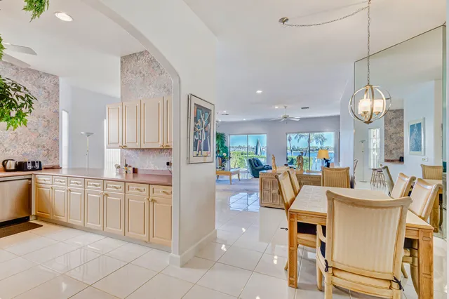 a large kitchen with cabinets chairs and entryway