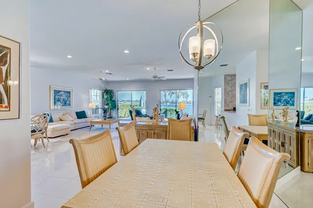 a living room with furniture a large window and a dining table with wooden floor