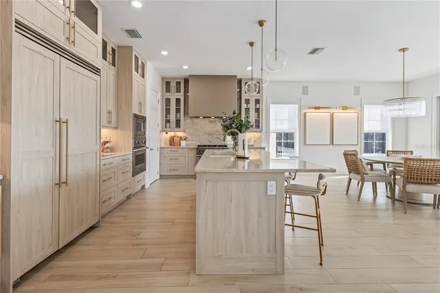 a kitchen with stainless steel appliances kitchen island granite countertop a table and chairs