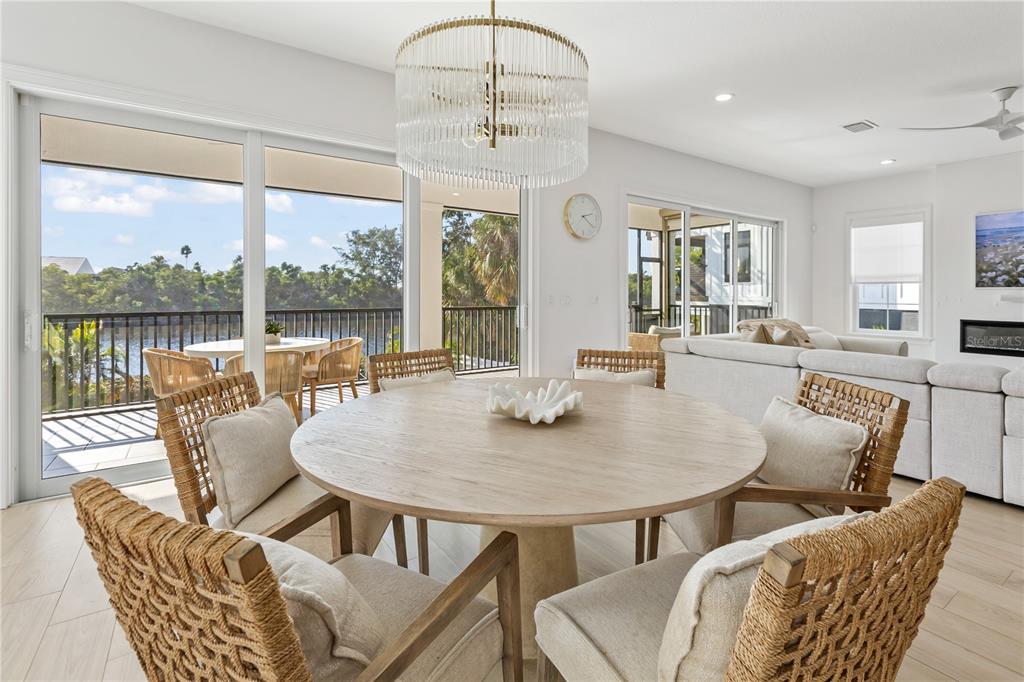 8008 Midnight Pass Road Sarasota, FL 34242 - Photo 18 of 61 a view of a dining room with furniture large windows and wooden floor