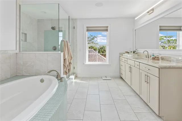 a spacious bathroom with a granite countertop sink a toilet a mirror and bathtub