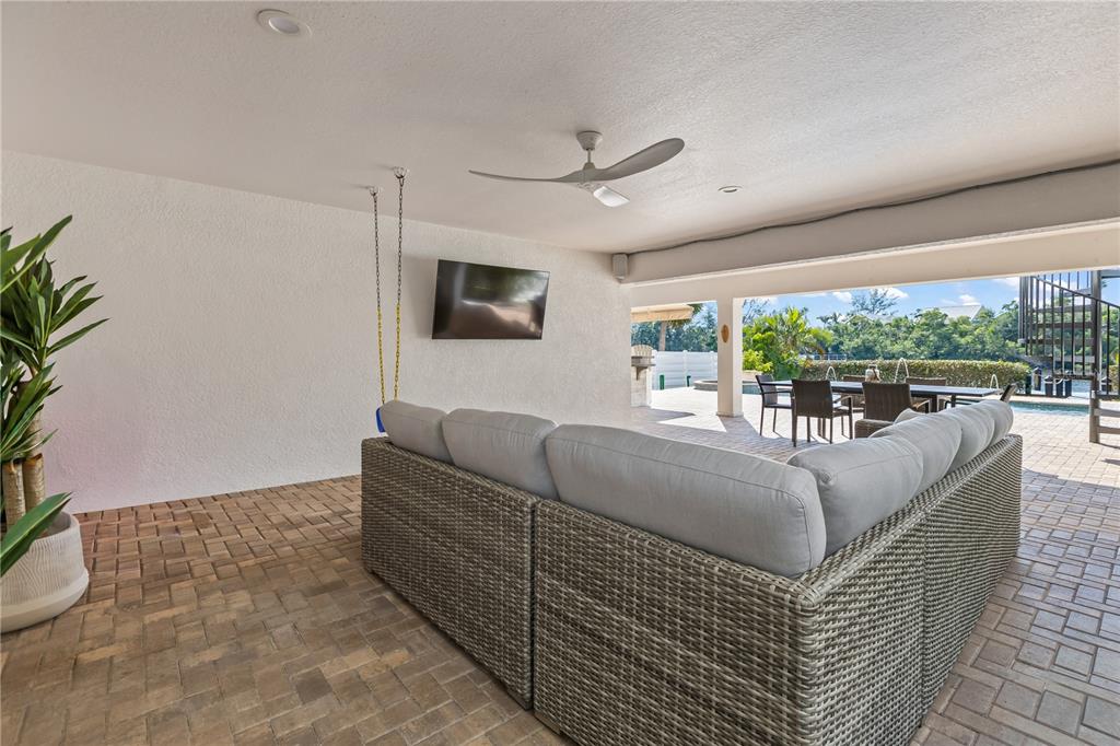 8008 Midnight Pass Road Sarasota, FL 34242 - Photo 41 of 61 a living room with couches floor to ceiling window and a flat screen tv