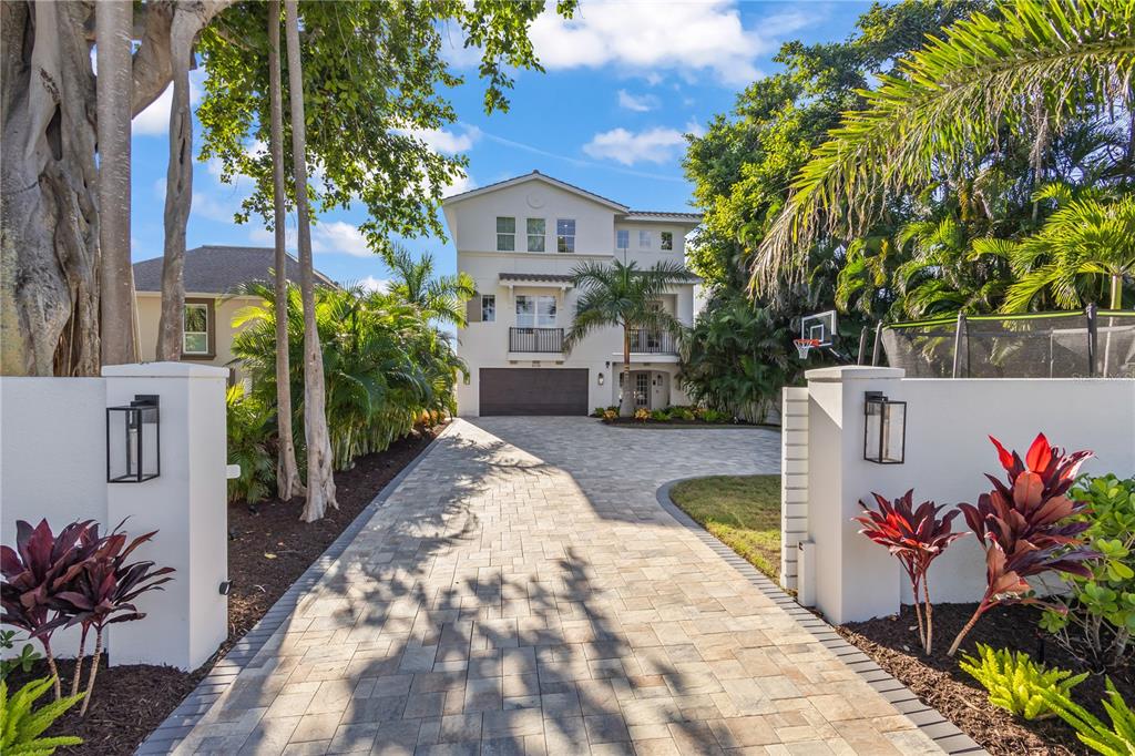 8008 Midnight Pass Road Sarasota, FL 34242 - Photo 48 of 61 a view of a white house with a small yard and potted plants