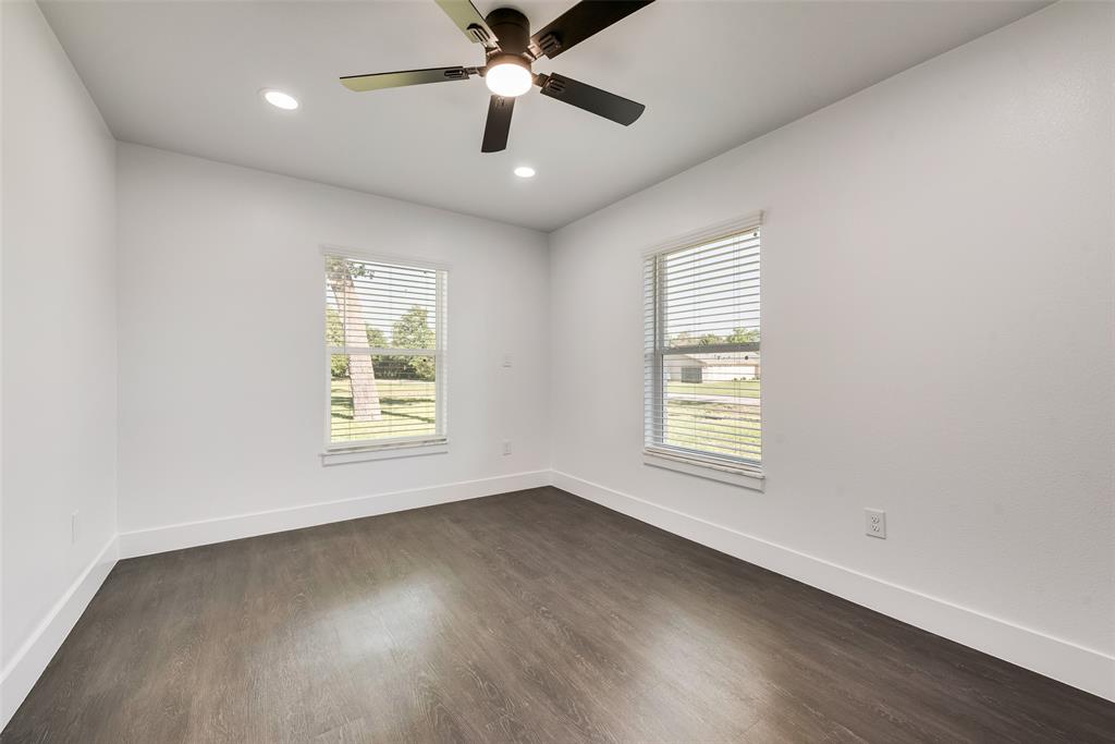 13827 Hiram Road Wills Point, TX 75169 - Photo 26 of 39 an empty room with wooden floor ceiling fan and windows
