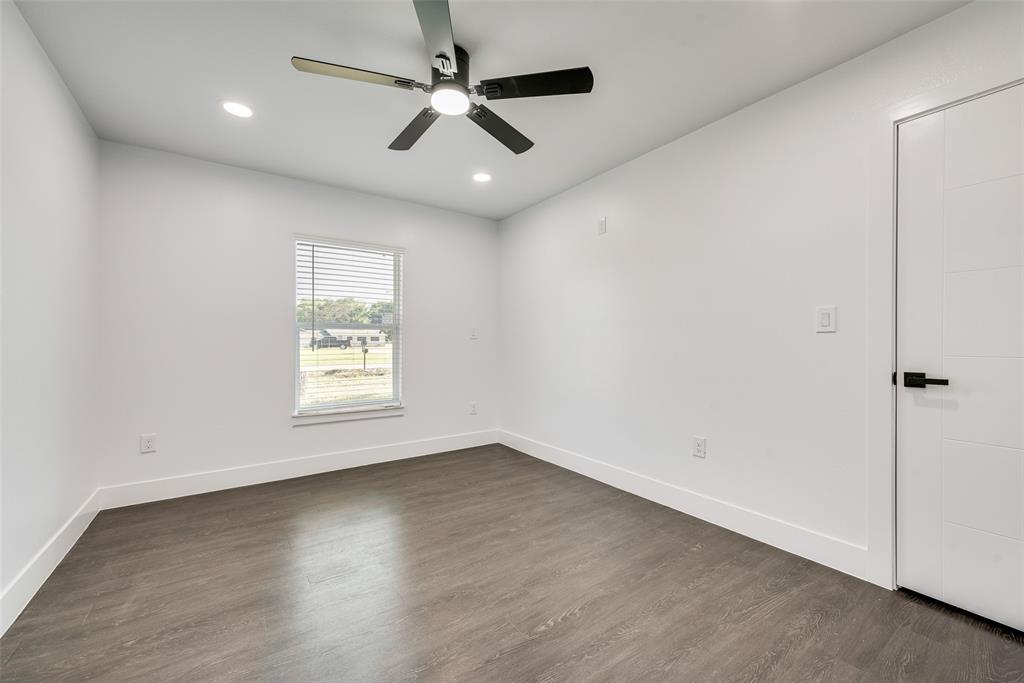 13827 Hiram Road Wills Point, TX 75169 - Photo 27 of 39 an empty room with wooden floor ceiling fan and windows