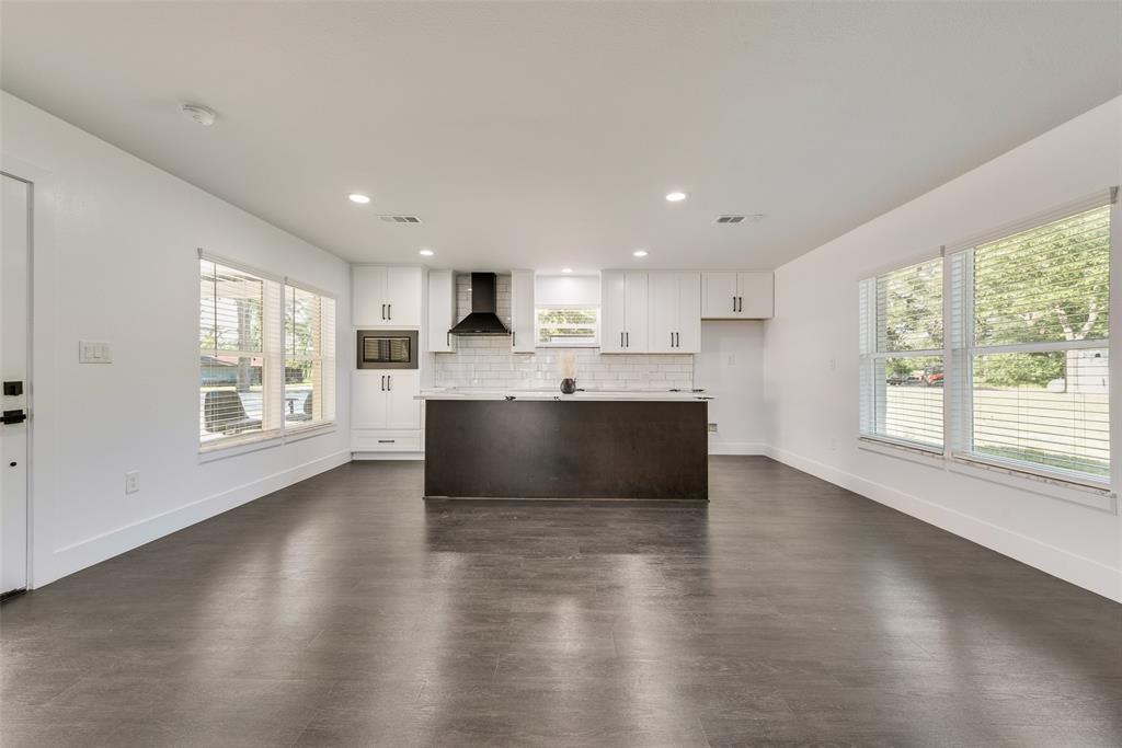 13827 Hiram Road Wills Point, TX 75169 - Photo 7 of 39 a large kitchen with kitchen island a sink wooden floor and a large window