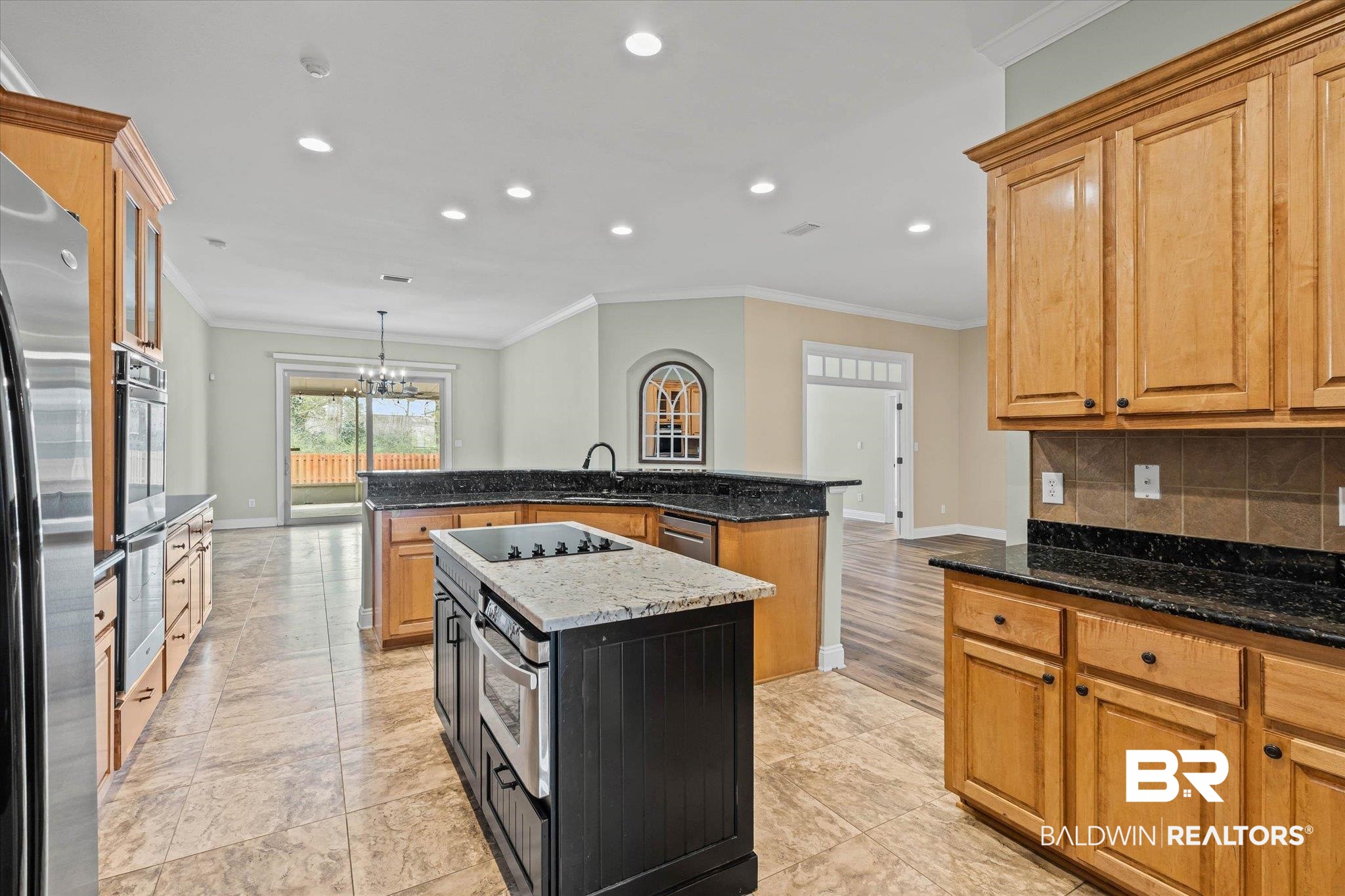 704 Edinburgh Avenue Foley, AL 36535 - Photo 12 of 32 Kitchen with ornamental molding, stainless steel appliances, dark stone counters, a chandelier, and backsplash