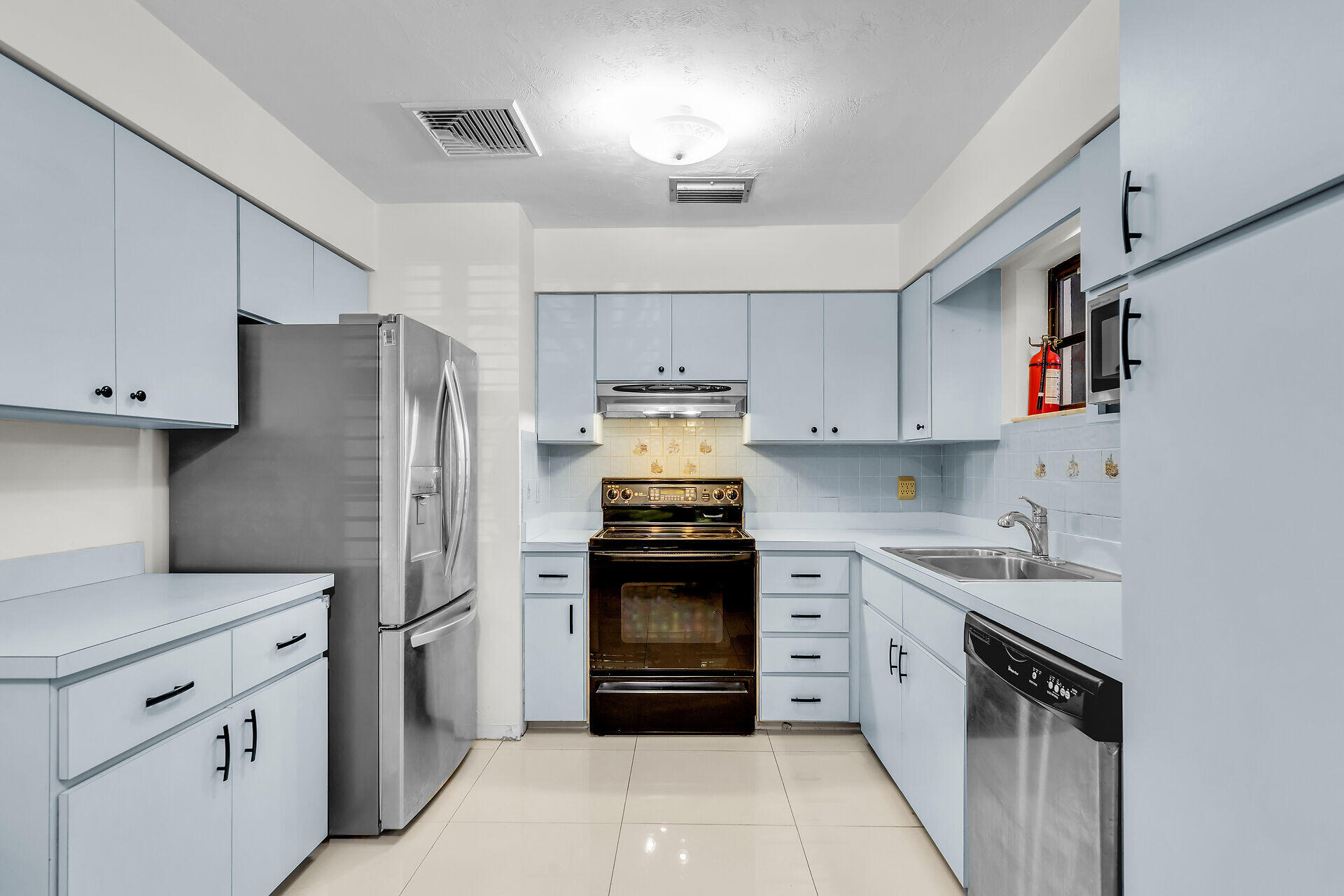 1044 Gibraltar Road Key Largo, FL 33037 - Photo 11 of 29 a kitchen with white cabinets and stainless steel appliances