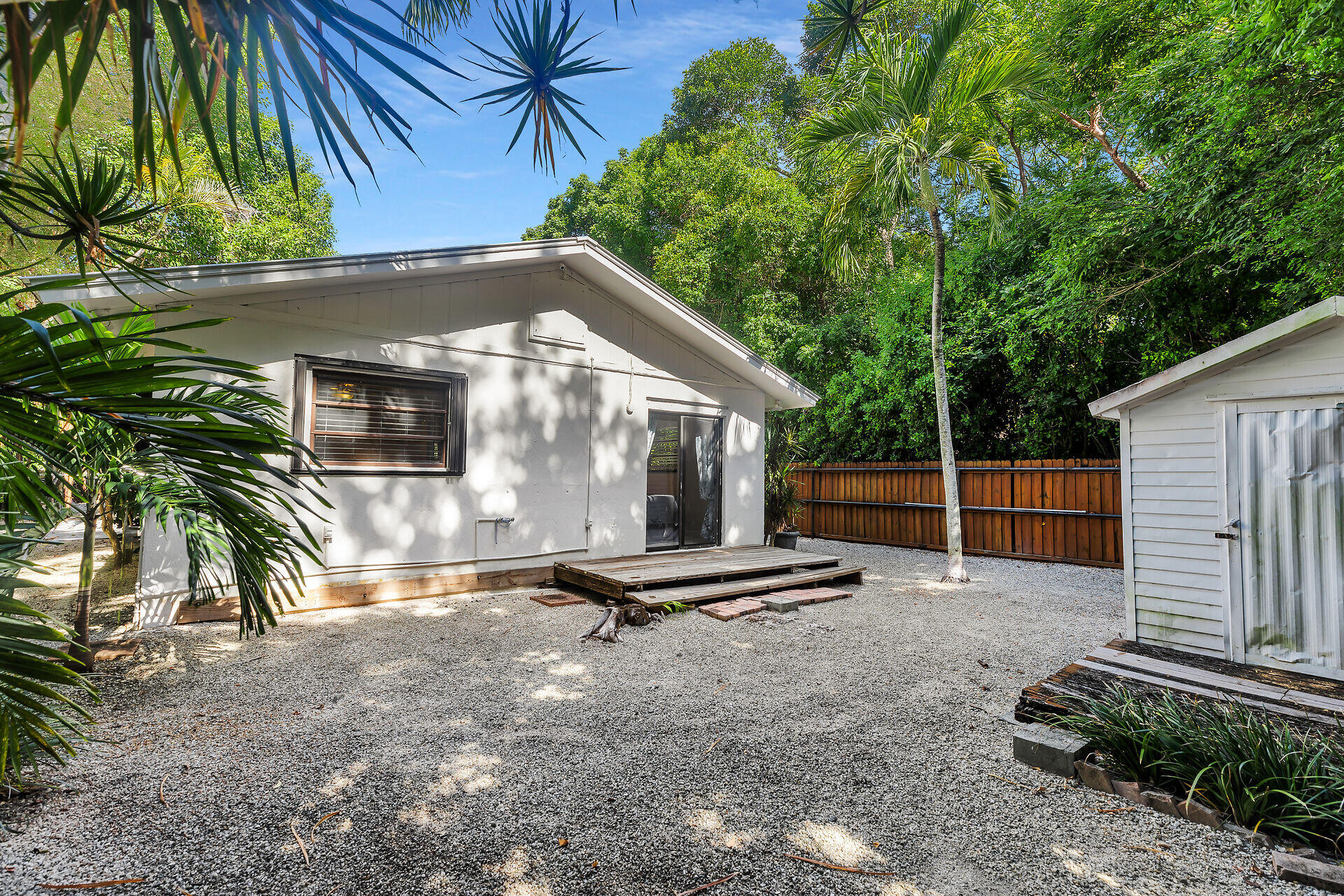 1044 Gibraltar Road Key Largo, FL 33037 - Photo 24 of 29 a backyard of a house with potted plants and large tree