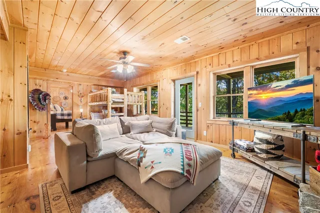 a living room with furniture a flat screen tv and a floor to ceiling window