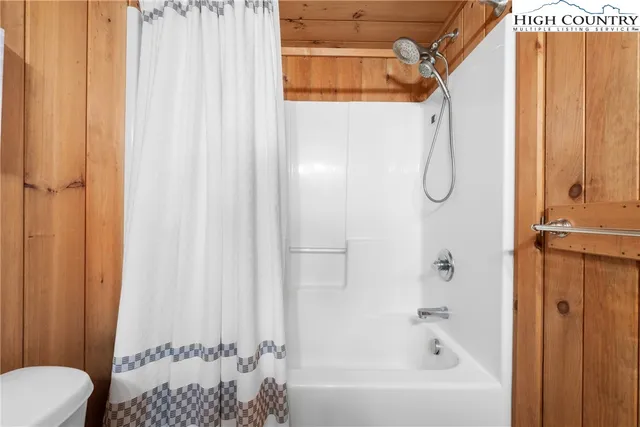 a bathroom with a shower curtain and a window