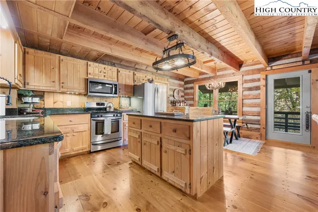 a kitchen with granite countertop a stove top oven a sink dishwasher and white cabinets with wooden floor