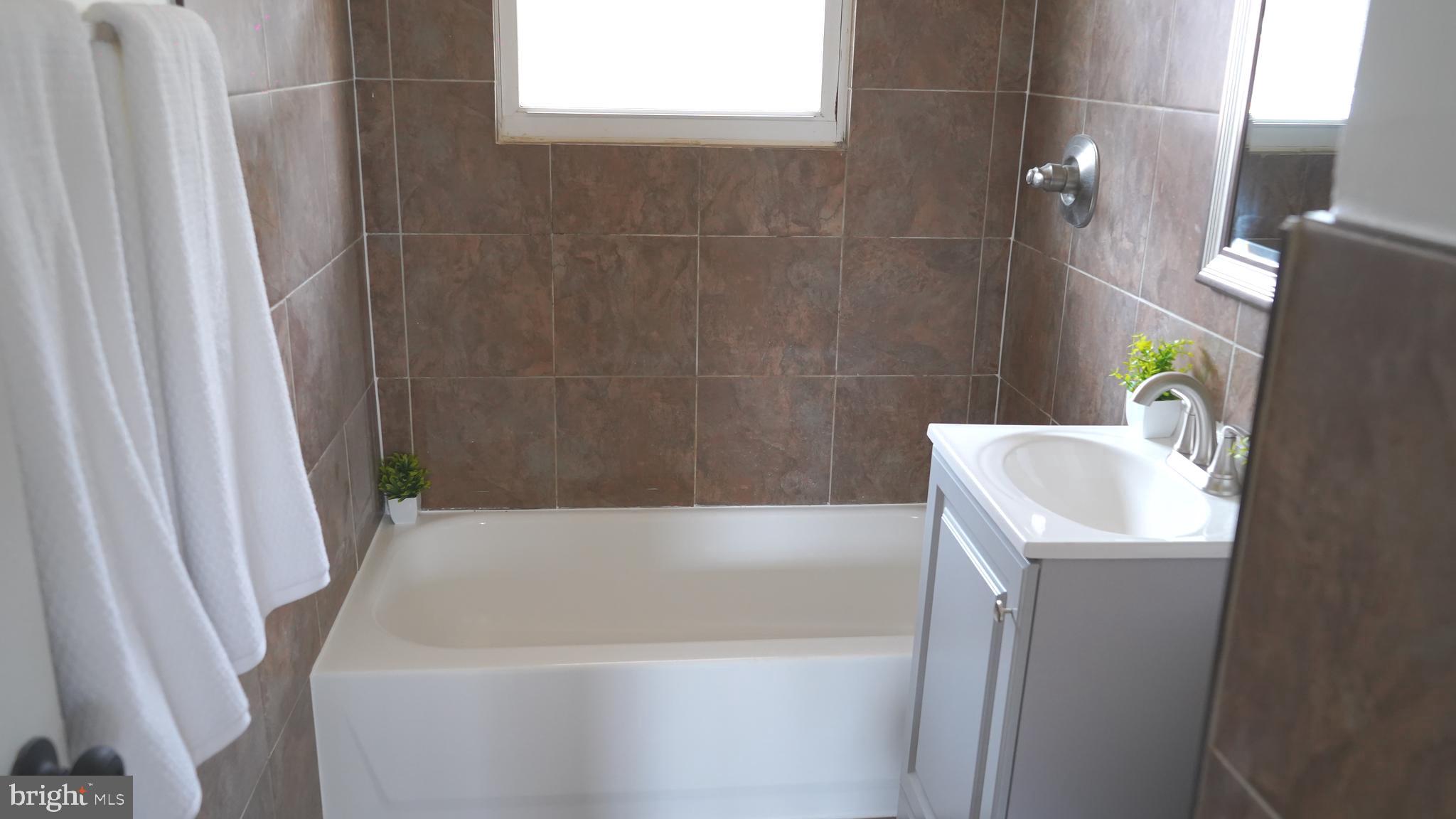 9300 Worrell Avenue Lanham, MD 20706 - Photo 11 of 63 a bathroom with a sink a bath tub and a shower