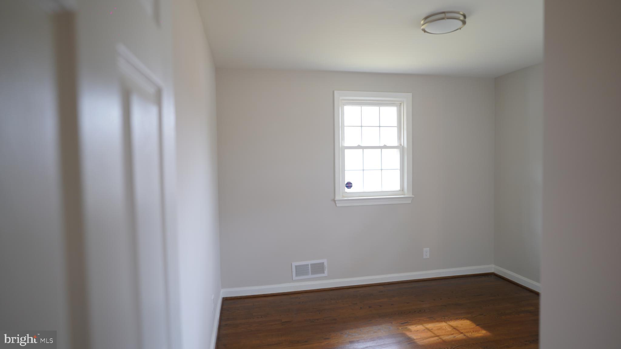 9300 Worrell Avenue Lanham, MD 20706 - Photo 19 of 63 a view of an empty room with wooden floor and a window