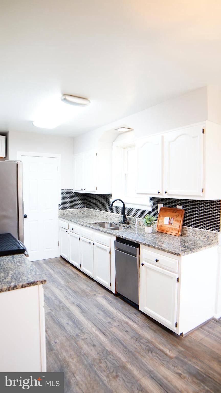 9300 Worrell Avenue Lanham, MD 20706 - Photo 56 of 63 a large kitchen with granite countertop a stove and a sink