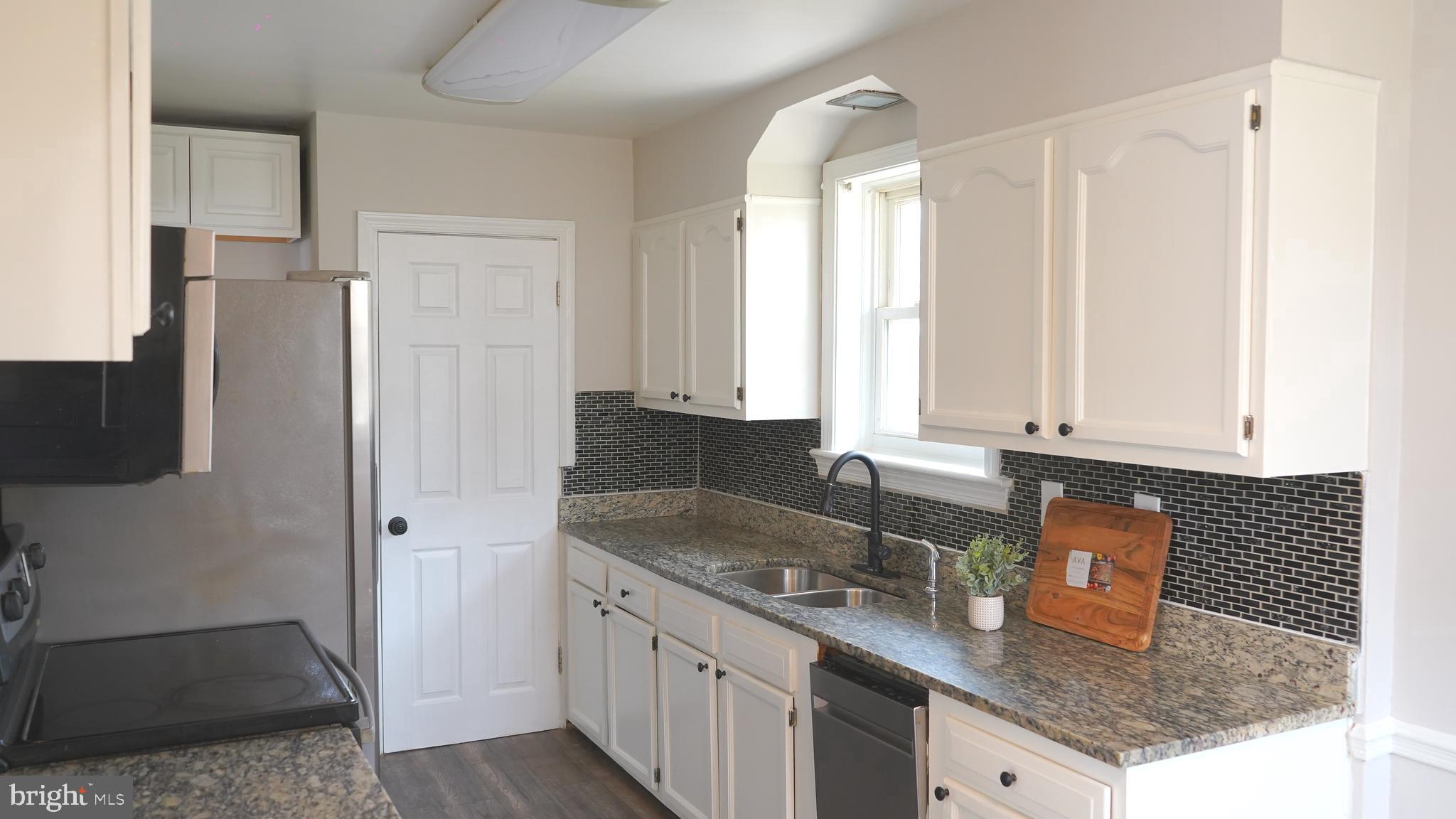 9300 Worrell Avenue Lanham, MD 20706 - Photo 8 of 63 a kitchen with granite countertop a sink a refrigerator and window