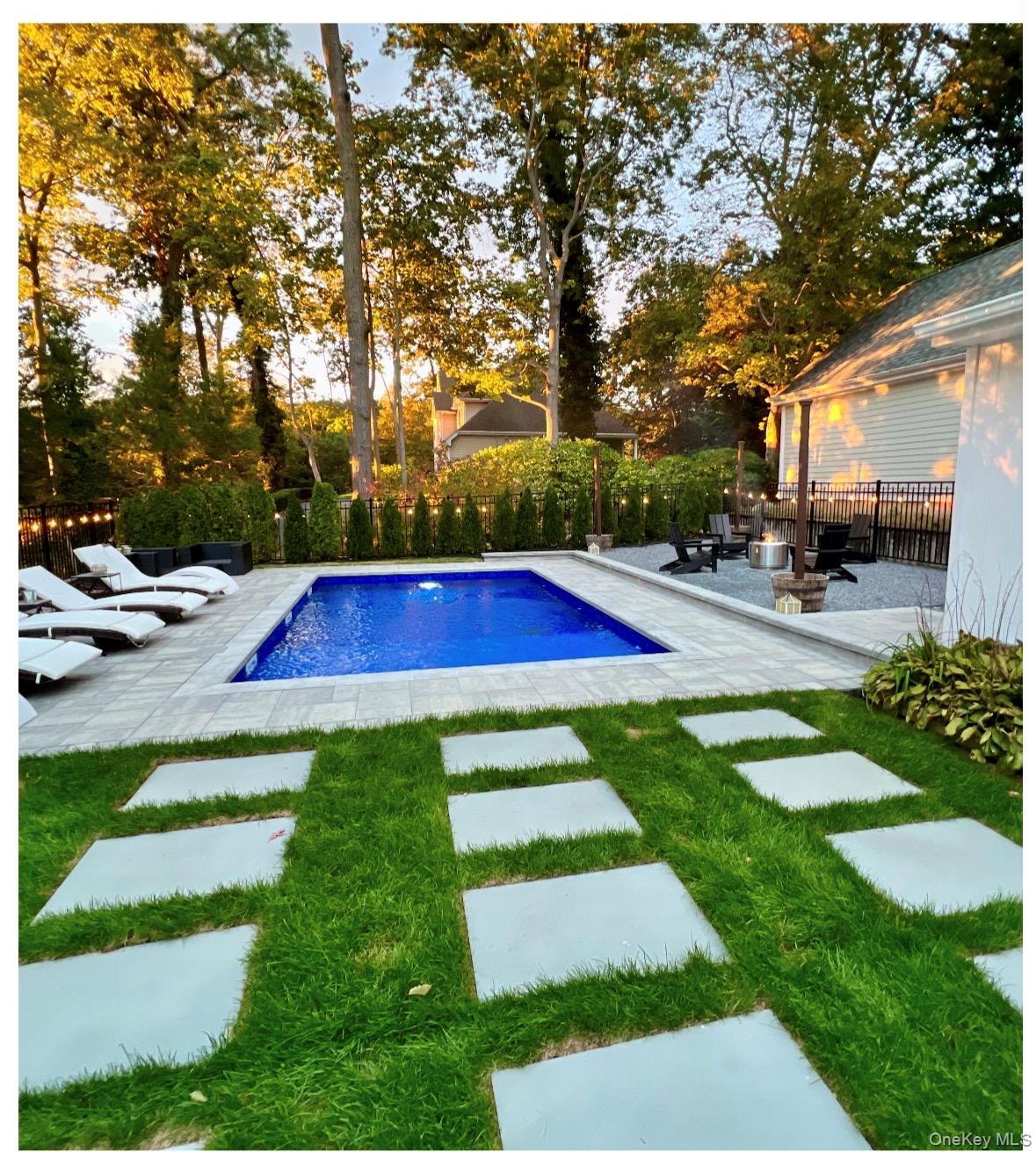 a view of backyard with swimming pool and green space