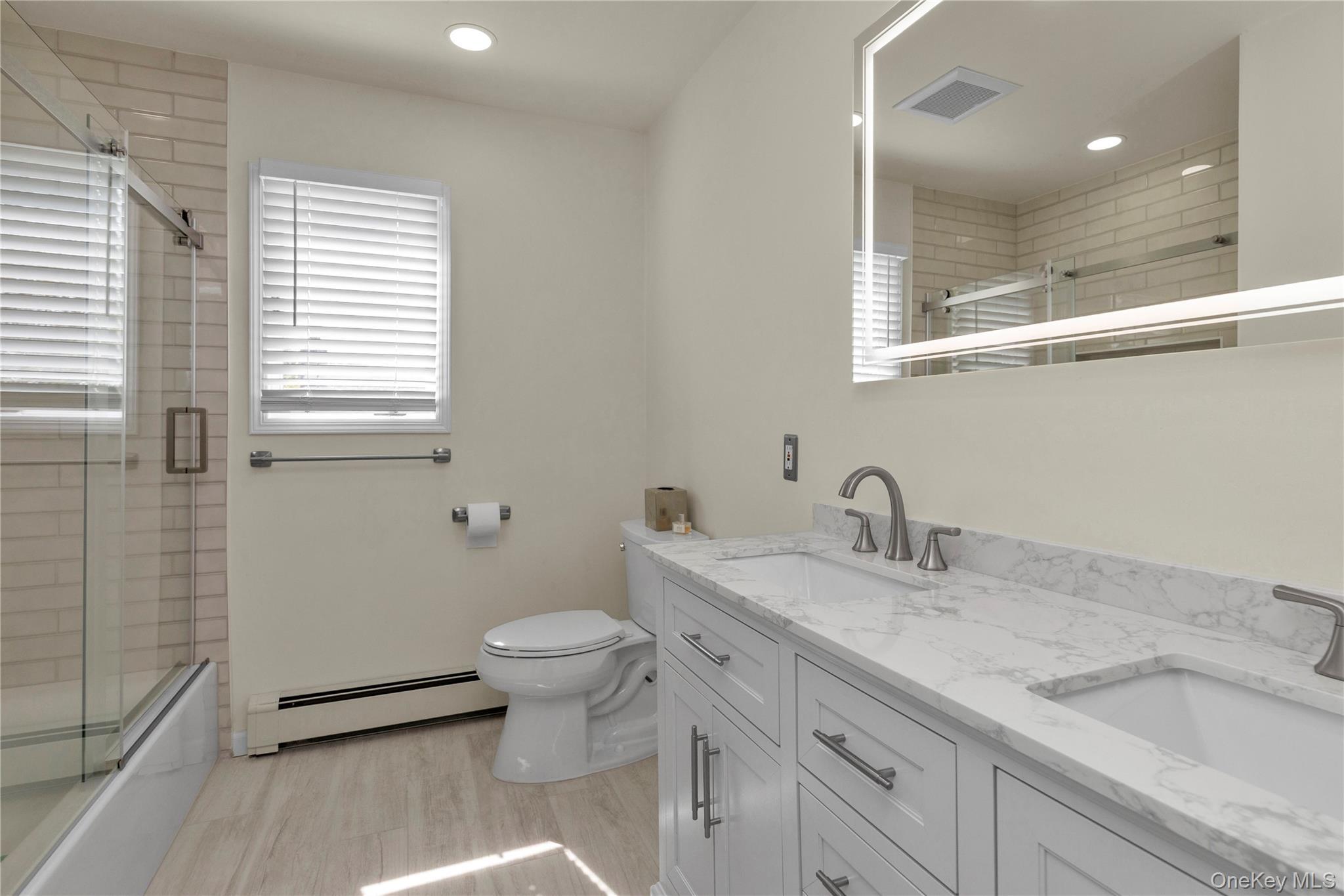 23 Grove Street Cold Spring Harbor, NY 11724 - Photo 16 of 21 a bathroom with a granite countertop sink a toilet and a mirror
