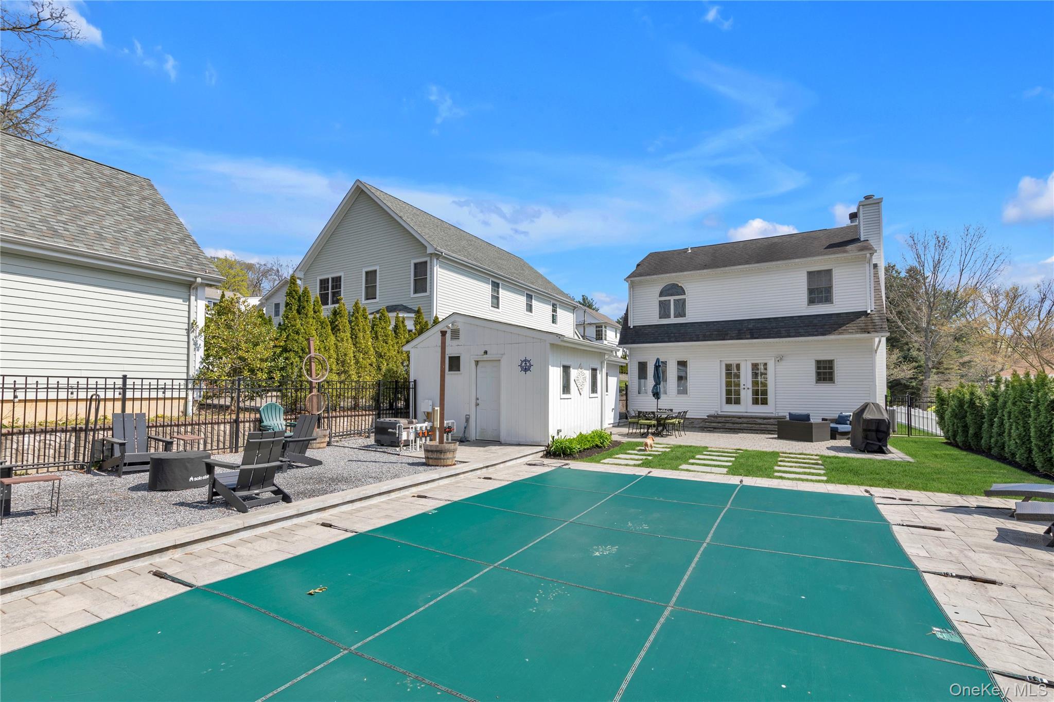 23 Grove Street Cold Spring Harbor, NY 11724 - Photo 20 of 21 a view of swimming pool with outdoor seating and house in the background