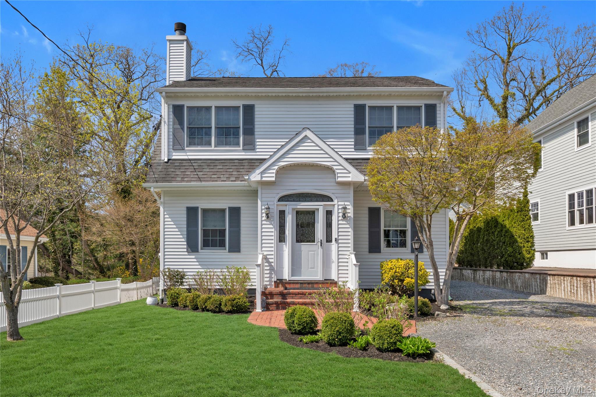 23 Grove Street Cold Spring Harbor, NY 11724 - Photo 2 of 21 a front view of a house with a yard and trees