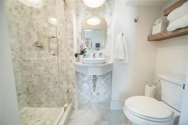 a bathroom with a sink a toilet and shower