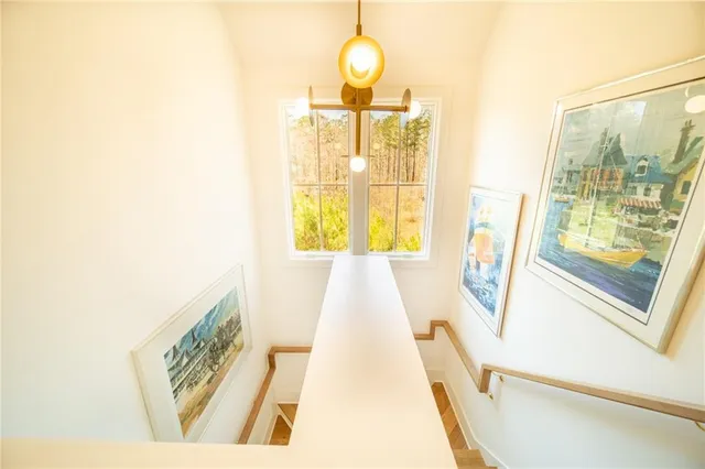 a view of a hallway with wooden floor and a chandelier