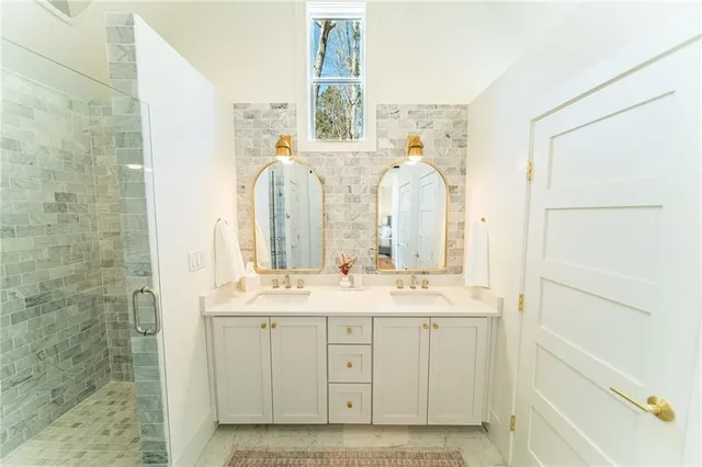 a spacious bathroom with a double vanity sink a mirror and a shower