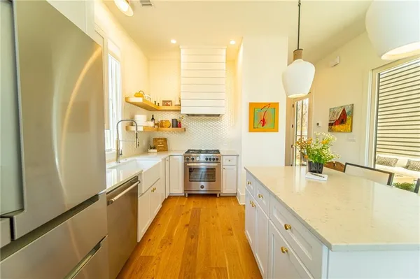 a large kitchen with a large window a sink and stainless steel appliances