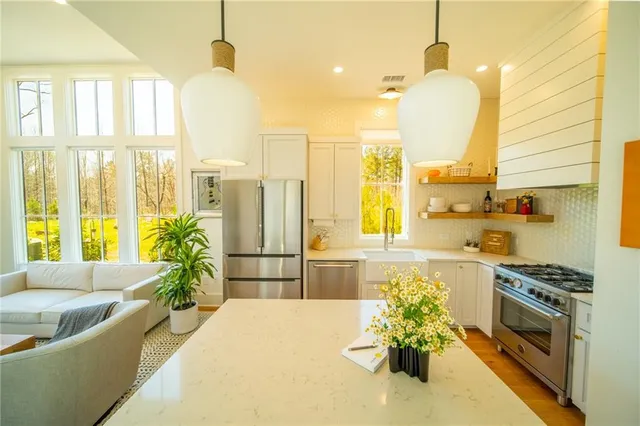 a kitchen with stainless steel appliances granite countertop a stove a sink and a refrigerator