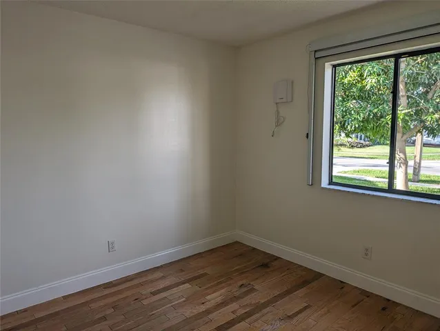 a room view with wooden floor and windows