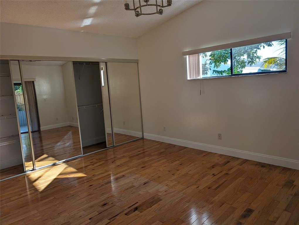 707 Southeast 3rd Avenue Dania Beach, FL 33004 - Photo 9 of 26 an empty room with wooden floor mirror and windows