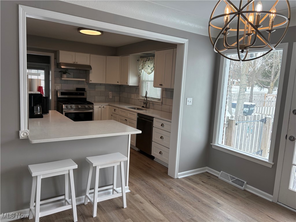 7817 Dalebrook Road Independence, OH 44131 - Photo 15 of 28 Kitchen featuring sink, hanging light fixtures, stainless steel range with gas cooktop, a kitchen breakfast bar, and dishwasher