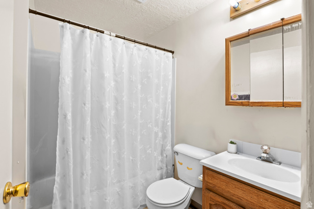 2327 880 North Provo, UT 84601 - Photo 10 of 15 Bathroom featuring a shower/tub combination with a white shower curtain, a wood-finish vanity with an integrated sink, a matching wood-finish medicine cabinet, and overhead vanity lighting