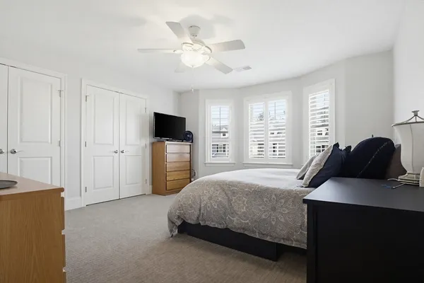 a bedroom with a bed a tv on table and chairs