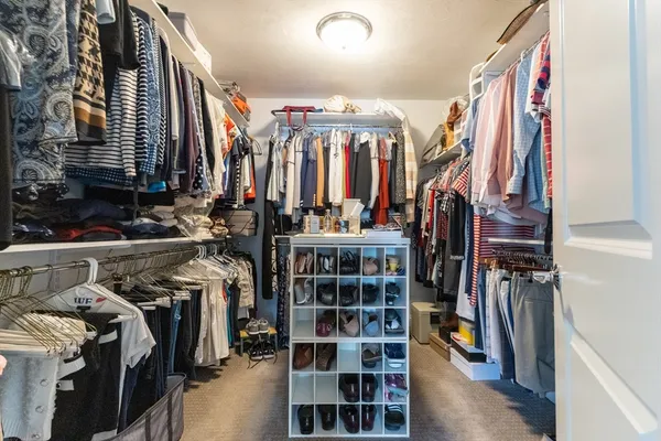 a view of walk in closet with clothes and shoes