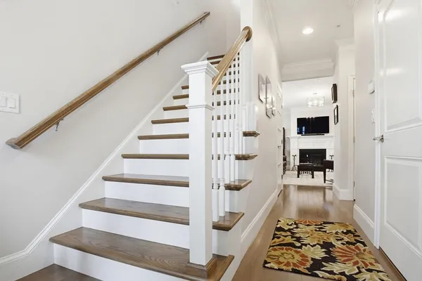 a view of staircase with white walls and rug
