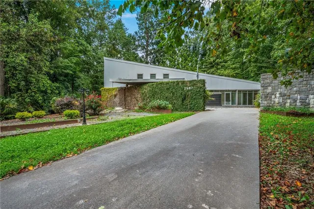 a view of a house with a yard and large tree