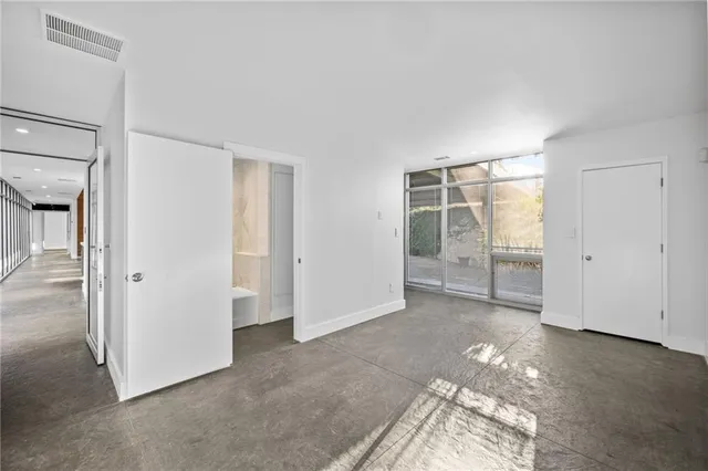 an empty room with windows and closet