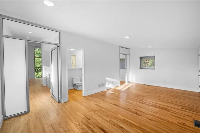 a very nice looking room with wooden floor and a bathroom