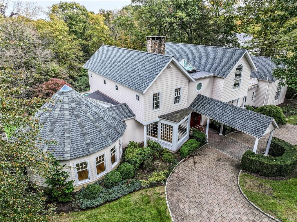 a aerial view of a house with a yard and large tree