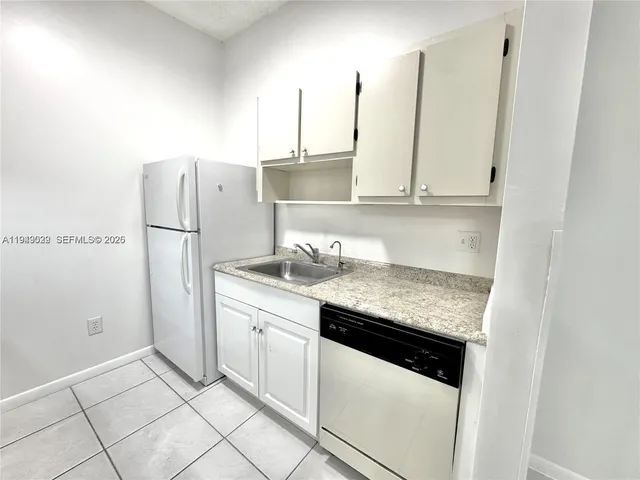 a kitchen with stainless steel appliances granite countertop a sink and a refrigerator