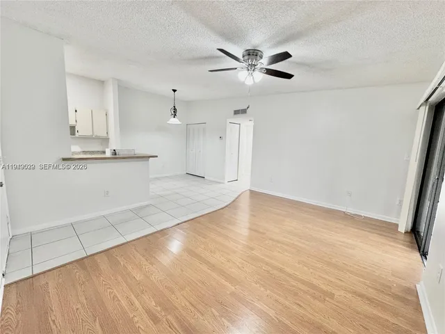 a view of a kitchen with kitchen island wooden floor and appliances