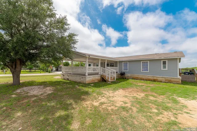a view of a house with backyard and a tree