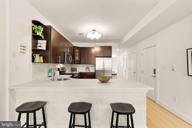 a kitchen with stainless steel appliances a sink cabinets and wooden floor