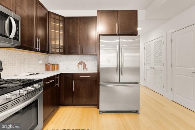 a kitchen with stainless steel appliances granite countertop a refrigerator and a stove