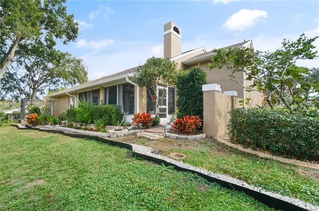 a front view of a house with a yard and potted plants
