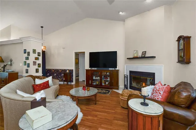 a living room with furniture a flat screen tv and a fireplace