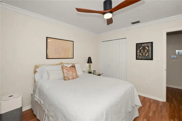 a bedroom with a bed and wooden floor