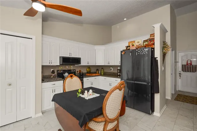 a kitchen with stainless steel appliances granite countertop a refrigerator and a stove top oven