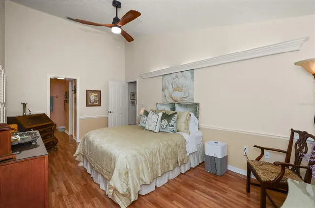 a bedroom with a bed wooden floor and a table